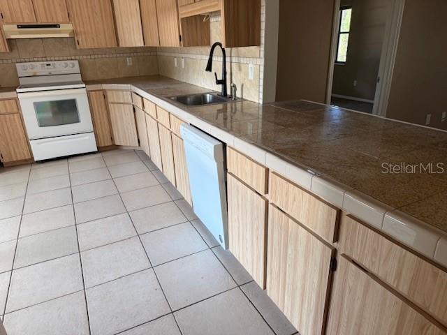 306 Cabot Street Inverness, FL 34452 - Photo 3 of 10 a kitchen with granite countertop a sink a stove and cabinets