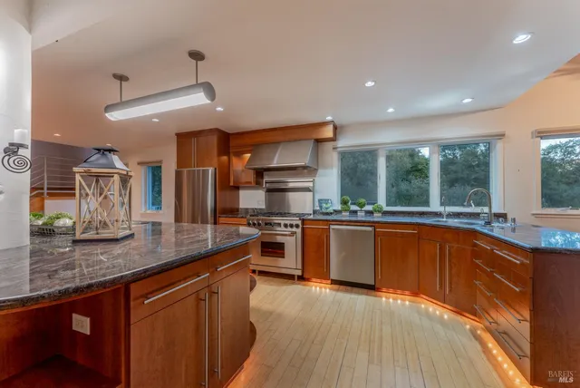 a kitchen with stainless steel appliances granite countertop a stove and a sink