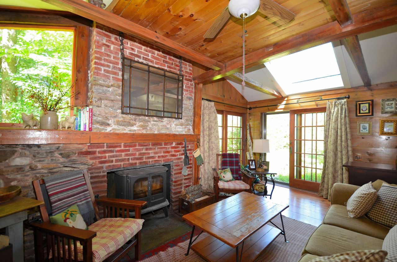 881 Stebbins Road Otis, MA 01253 - Photo 14 of 20 a living room with furniture a fireplace and a floor to ceiling window