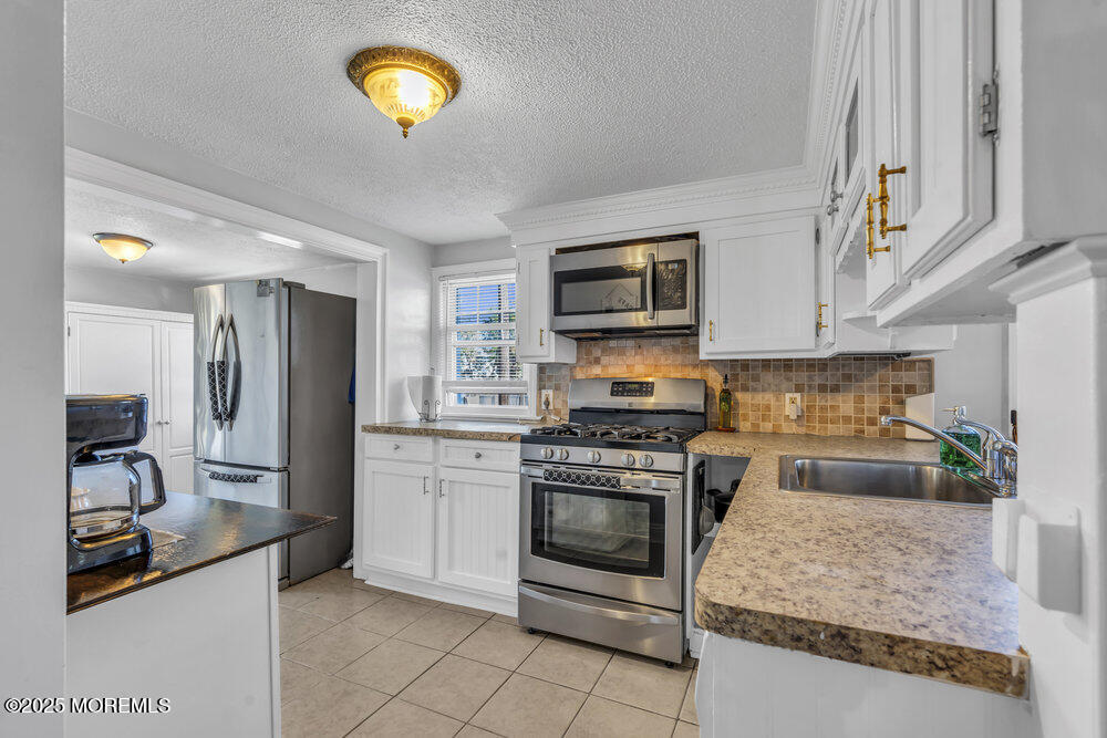 401 Joline Avenue Long Branch, NJ 07740 - Photo 9 of 30 a kitchen with stainless steel appliances granite countertop a stove top oven a sink and a granite counter tops