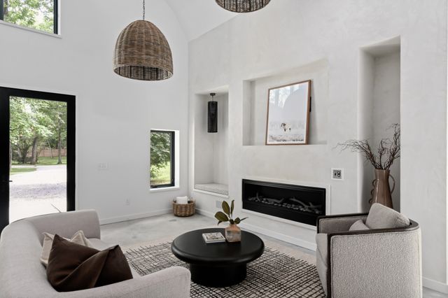 a living room with furniture a fireplace and a chandelier