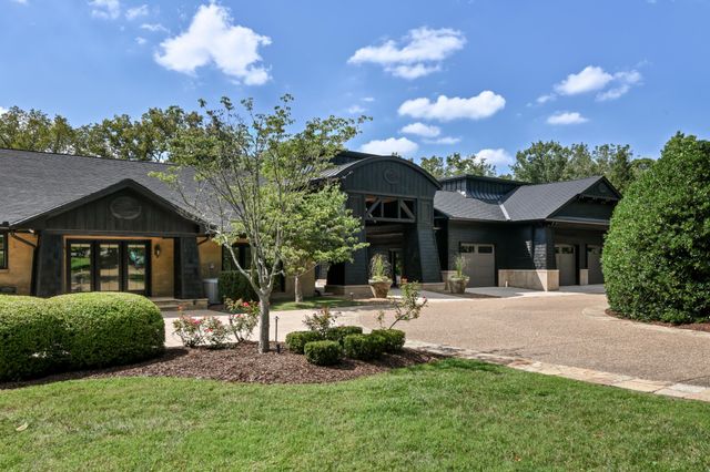 a front view of a house with a yard and potted plants