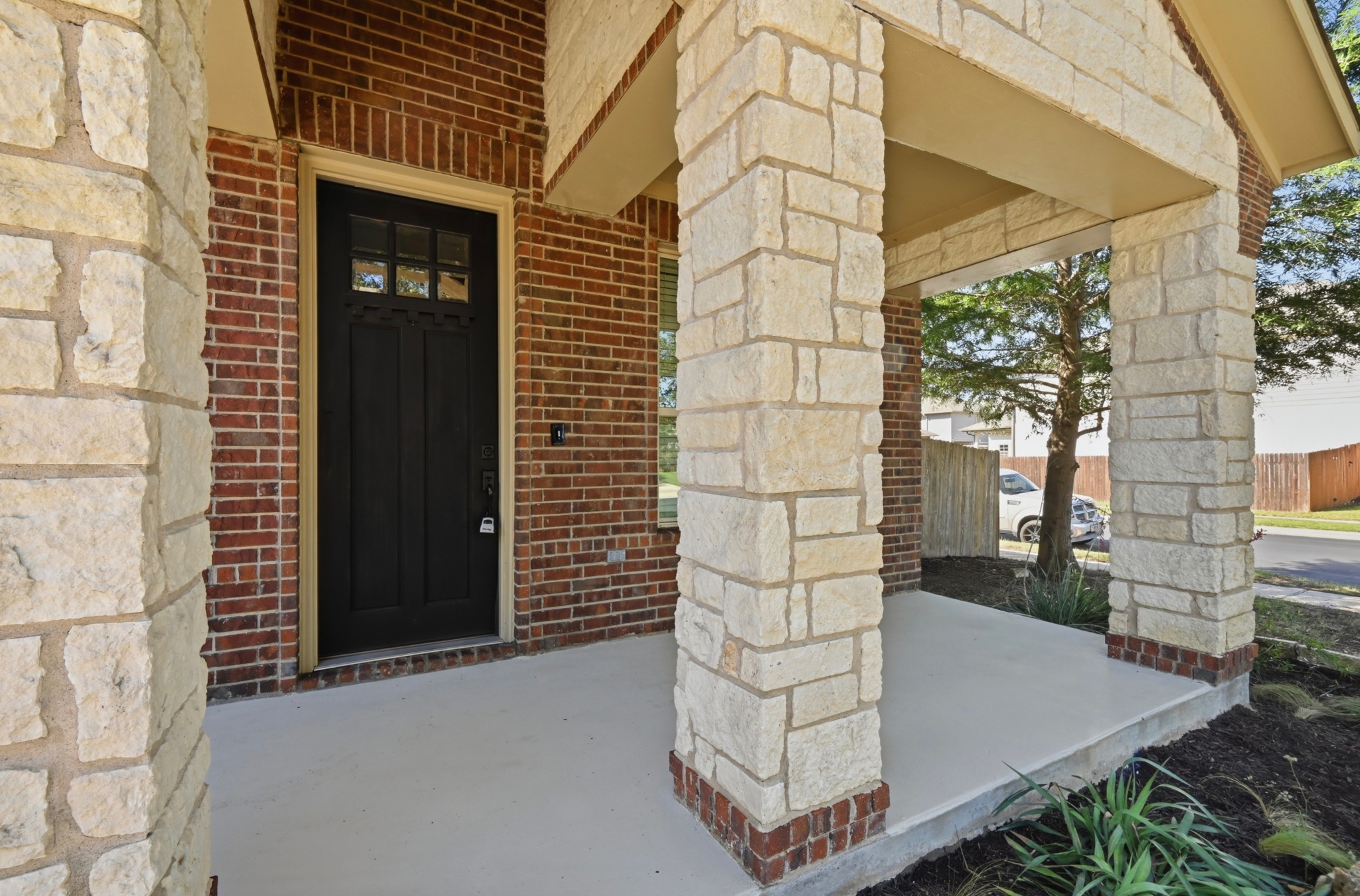 351 Wincliff Drive Buda, TX 78610 - Photo 4 of 40 A welcoming front porch with natural stone pillars and brick accents for exceptional curb appeal.