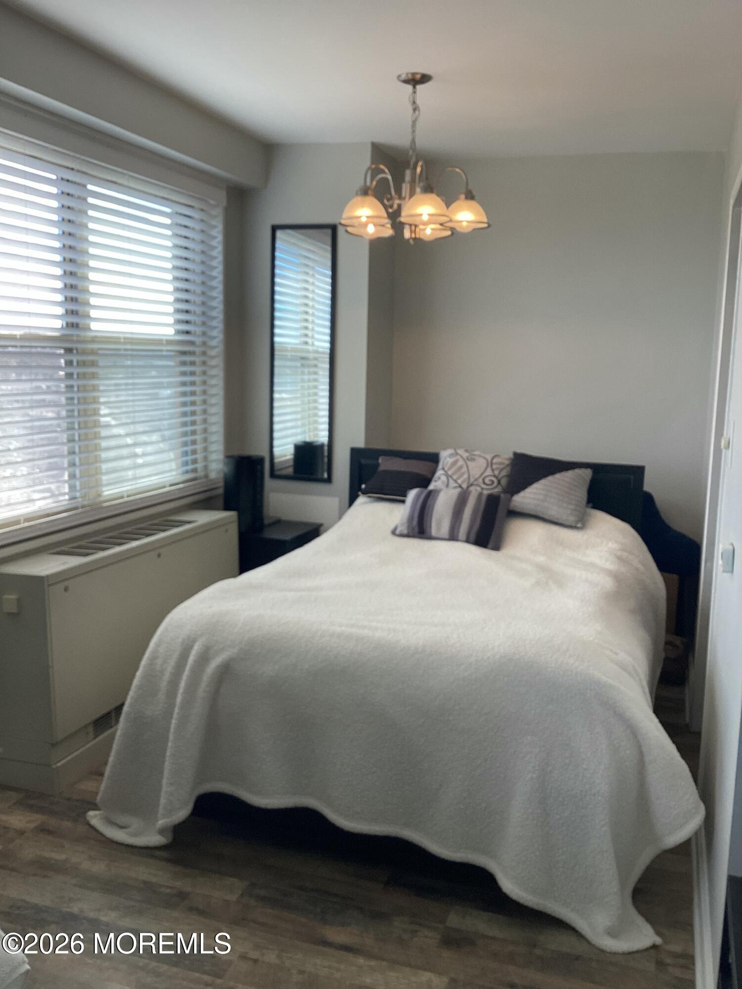 28 Riverside Avenue, Unit 9D Red Bank, NJ 07701 - Photo 5 of 15 a bedroom with a bed and a chandelier