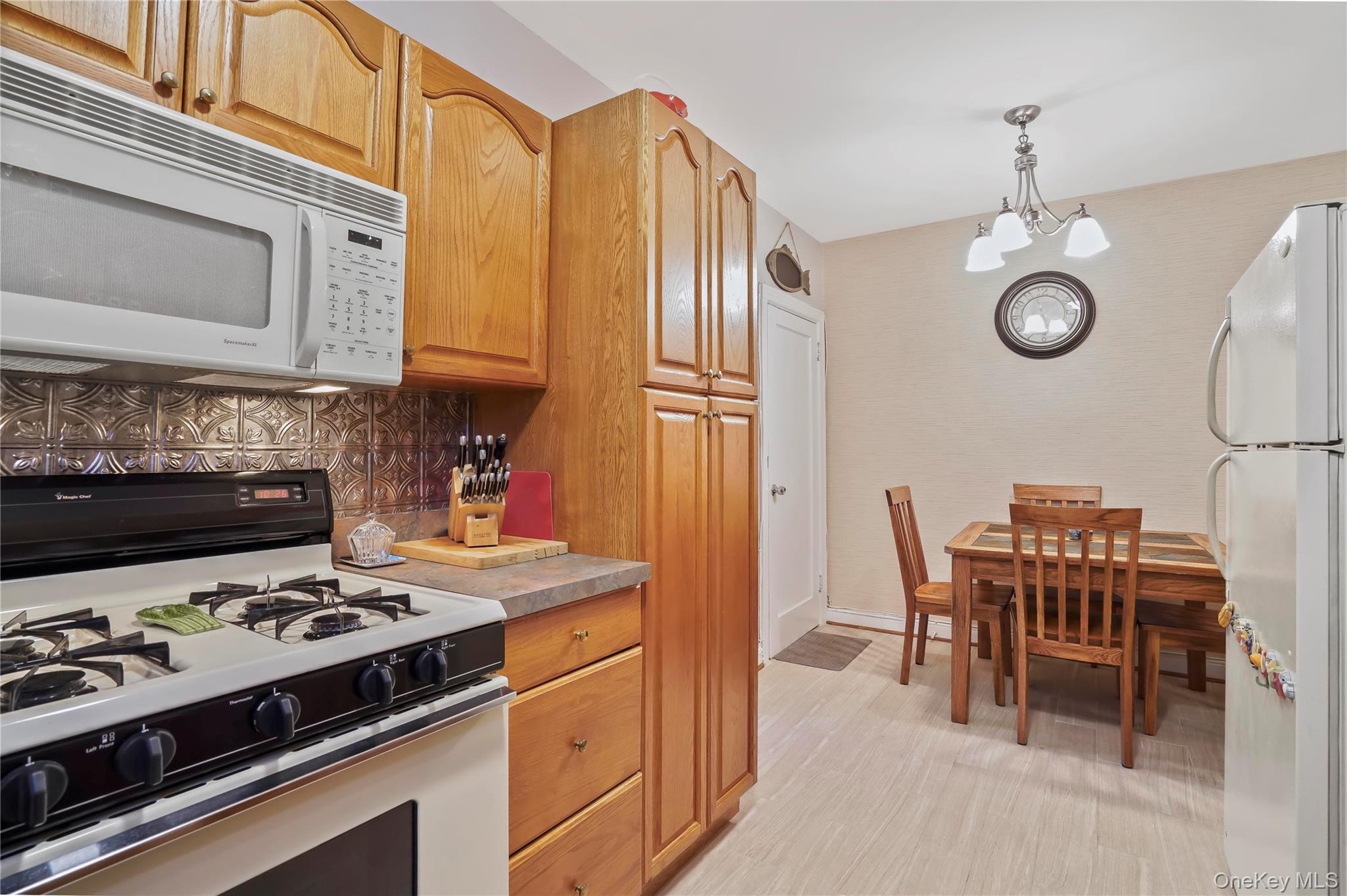 43-06 57th Street Queens, NY 11377 - Photo 11 of 21 a kitchen with stainless steel appliances a stove a table and chairs