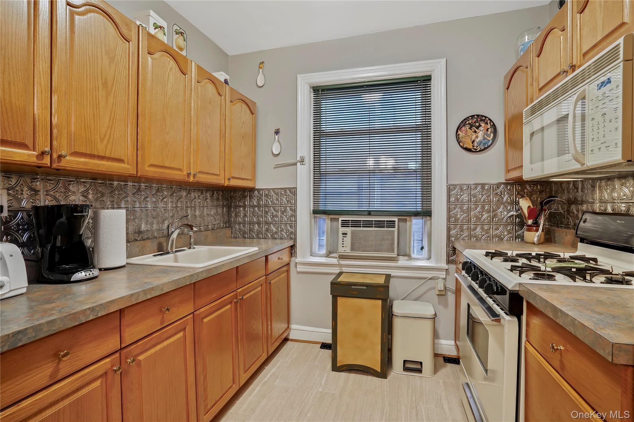 43-06 57th Street Queens, NY 11377 - Photo 13 of 21 a kitchen with stainless steel appliances granite countertop a stove a sink dishwasher and cabinets with wooden floor