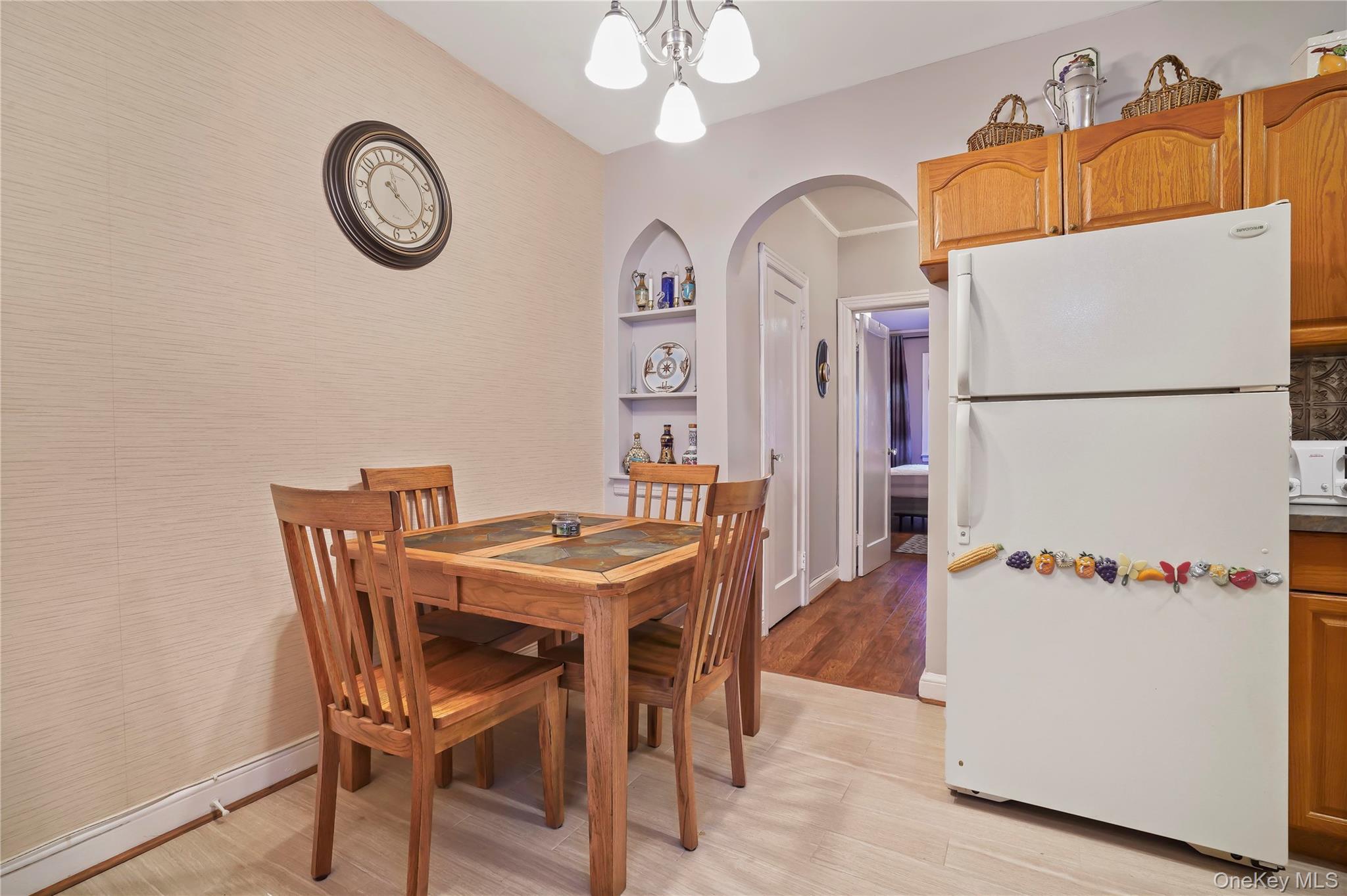 43-06 57th Street Queens, NY 11377 - Photo 17 of 21 a white kitchen with a refrigerator a stove top oven a chimney and a refrigerator