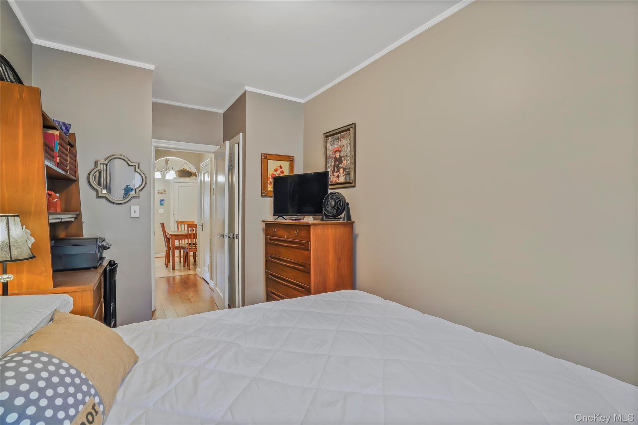 43-06 57th Street Queens, NY 11377 - Photo 9 of 21 a bedroom with a bed and a flat tv screen on dresser