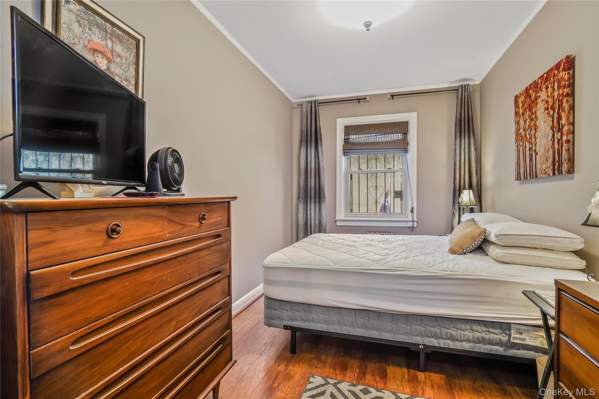 43-06 57th Street Queens, NY 11377 - Photo 10 of 21 a bedroom with a bed and a flat screen tv