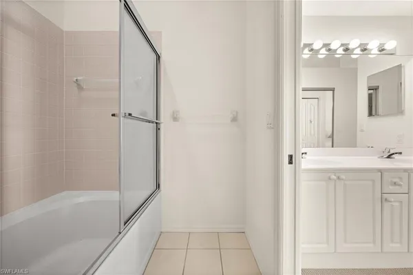 a bathroom with a tub sink and mirror