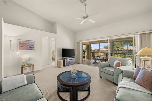 a living room with furniture a flat screen tv and a large window