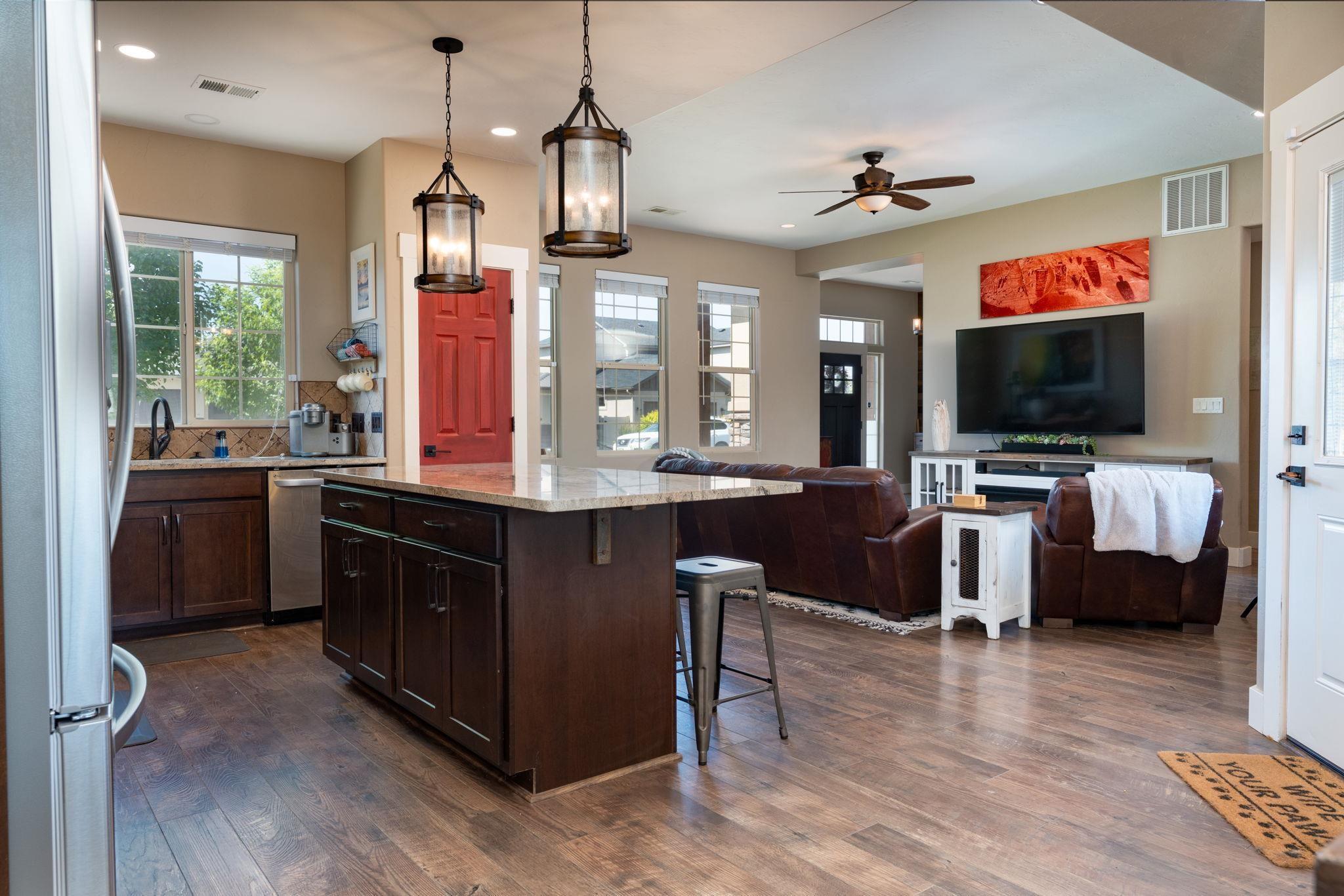 1139 Aspen Village Loop Fruita, CO 81521 - Photo 7 of 21 a kitchen with kitchen island granite countertop a sink dishwasher a stove and a dining table with wooden floor