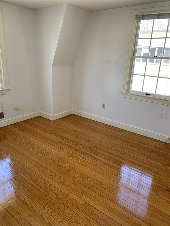 59 Atlantic Avenue, Unit A Marblehead, MA 01945 - Photo 3 of 4 an empty room with wooden floor and windows