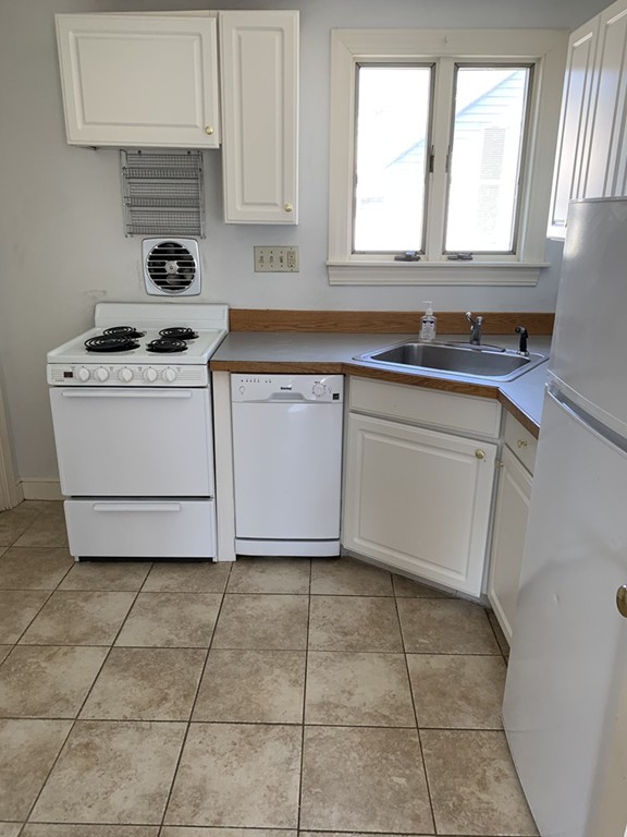 59 Atlantic Avenue, Unit A Marblehead, MA 01945 - Photo 4 of 4 a kitchen with a stove a sink and a window