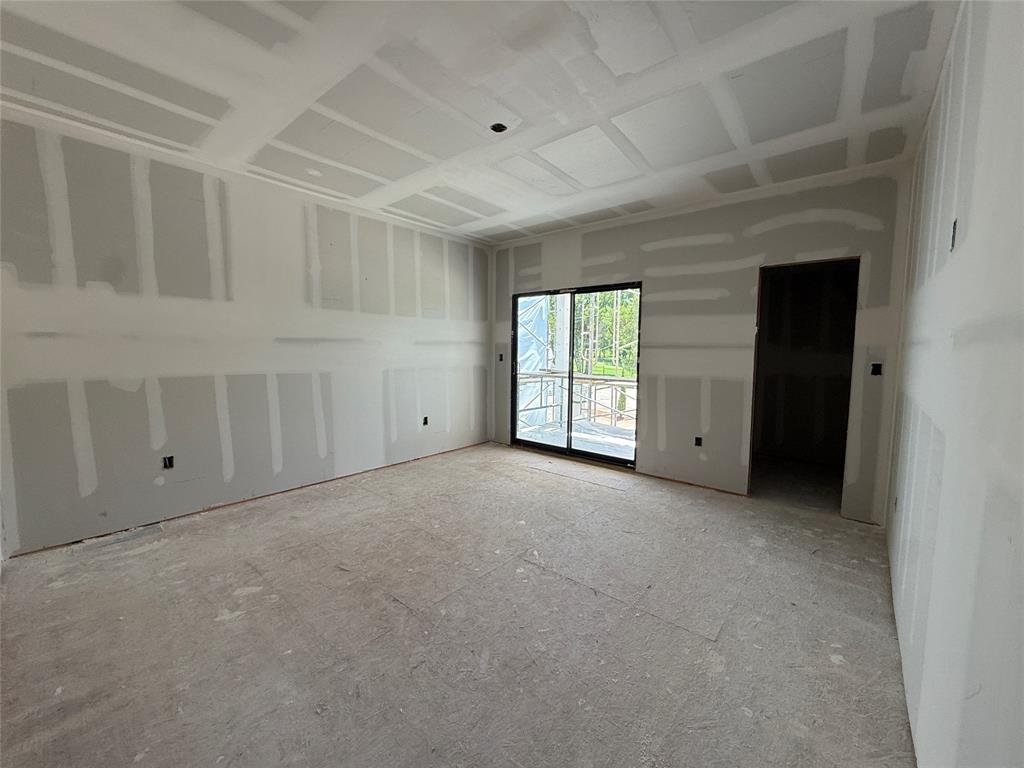 New construction interior with drywall installation, featuring a coffered ceiling and a large sliding glass door