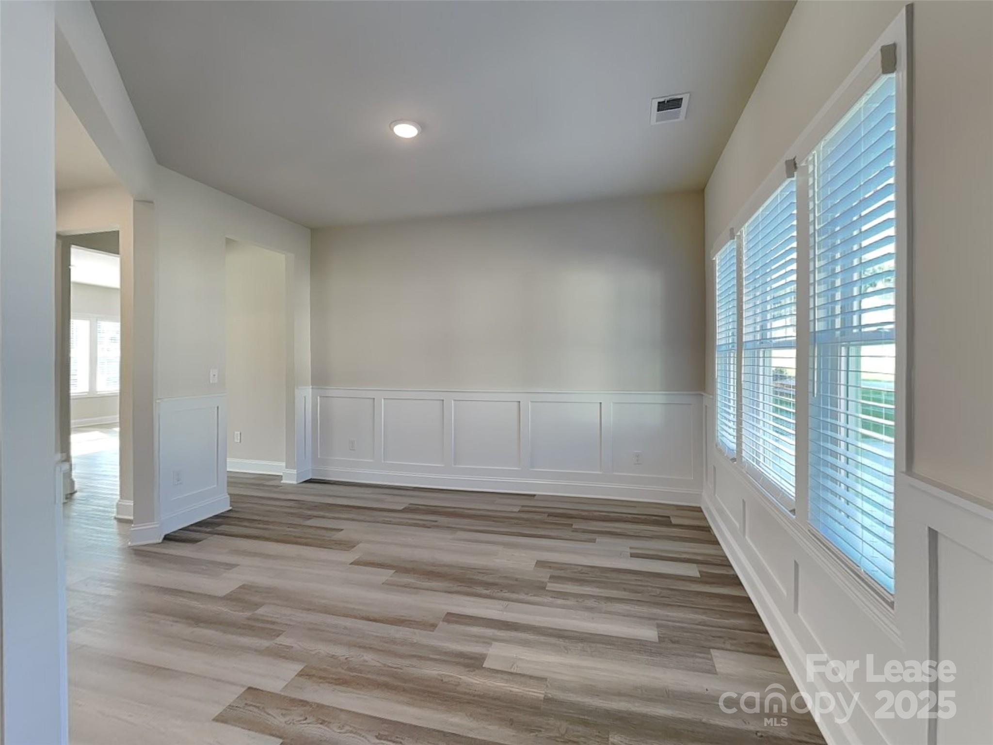 212 Queenshall Road Mooresville, NC 28117 - Photo 5 of 15 a view of an empty room with wooden floor and a window