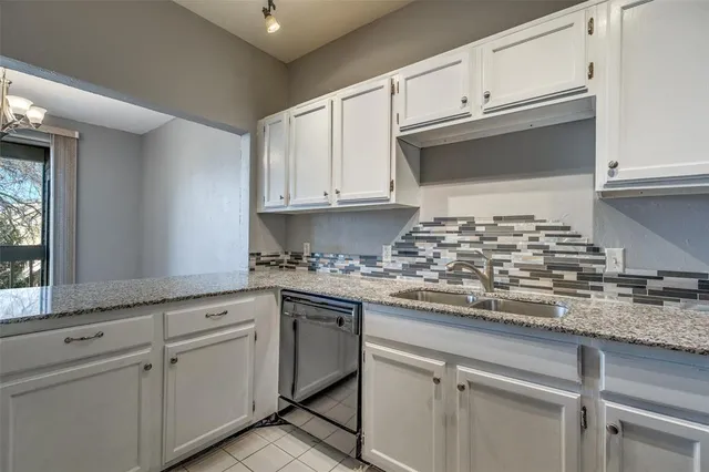 a kitchen with granite countertop white cabinets and white appliances