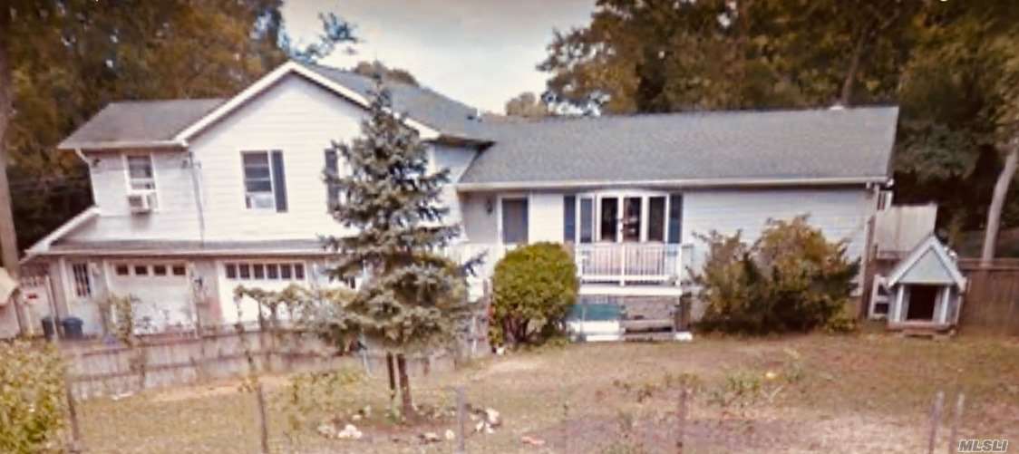 a front view of house with yard and trees around