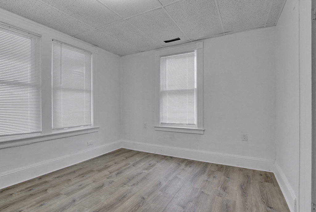 1397 Worcester Street, Unit 2 Springfield, MA 01151 - Photo 12 of 15 an empty room with wooden floor and windows