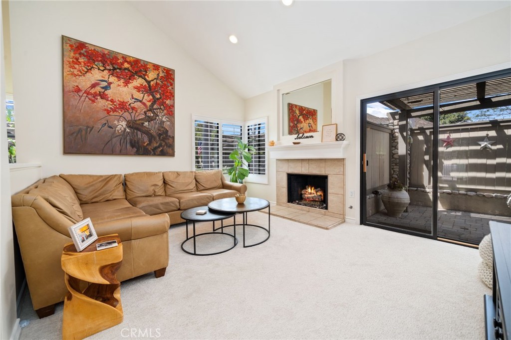 49 Pinewood, Unit 25 Irvine, CA 92604 - Photo 15 of 42 a living room with furniture a fireplace and a flat screen tv