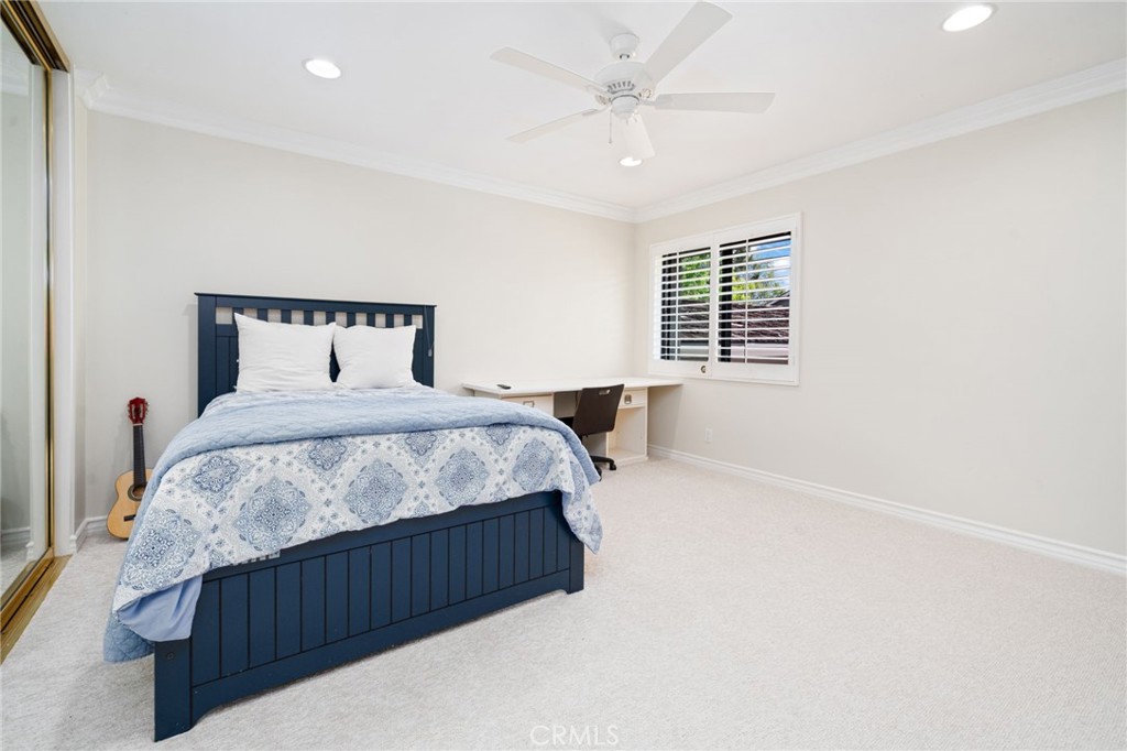 49 Pinewood, Unit 25 Irvine, CA 92604 - Photo 27 of 42 a bedroom with a large bed and a chandelier