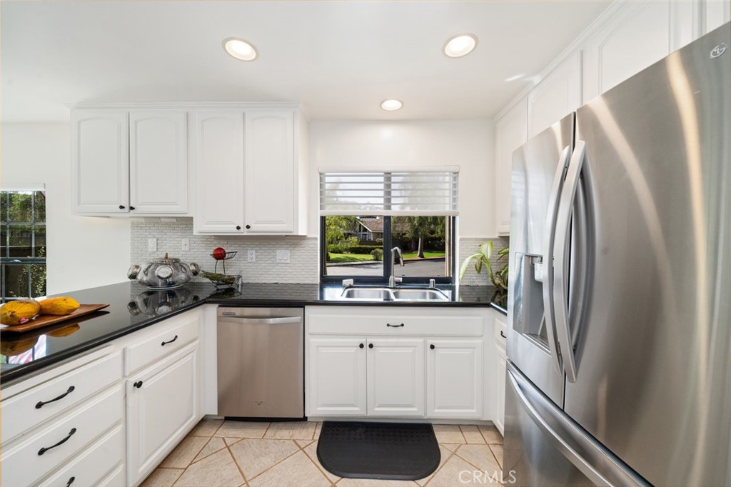 49 Pinewood, Unit 25 Irvine, CA 92604 - Photo 9 of 42 a kitchen with white cabinets and stainless steel appliances