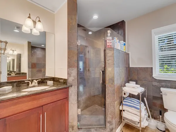a bathroom with a sink a toilet and shower