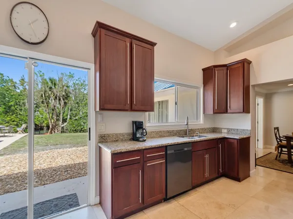 a kitchen with stainless steel appliances granite countertop a sink a stove and a wooden cabinets