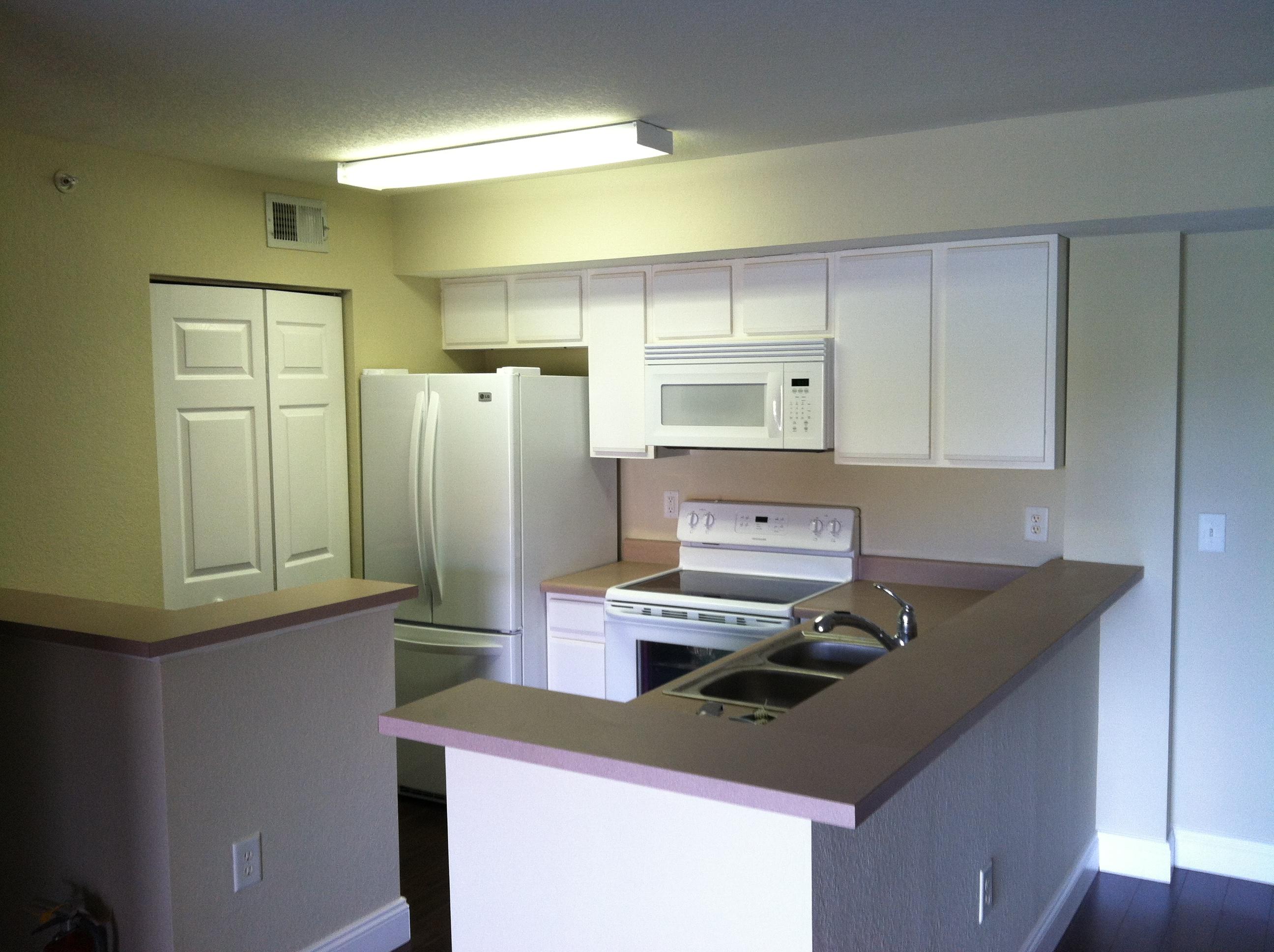 171 Southwest Palm Drive, Unit 205 Port St. Lucie, FL 34986 - Photo 1 of 8 a kitchen that has a cabinets and a stove