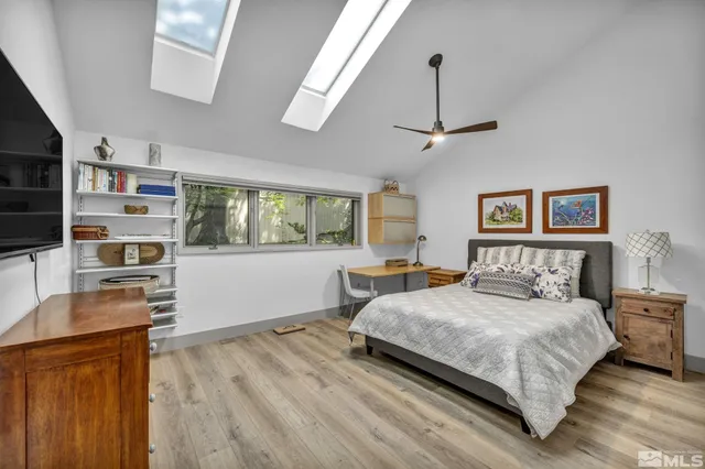 a bedroom with a bed and a flat tv screen on dresser
