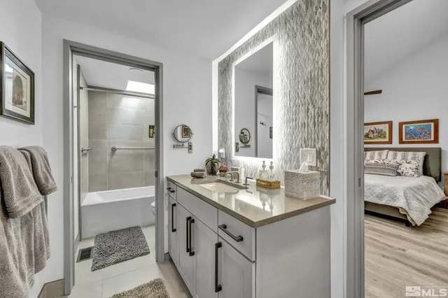a en suite bathroom with a granite countertop sink and a mirror