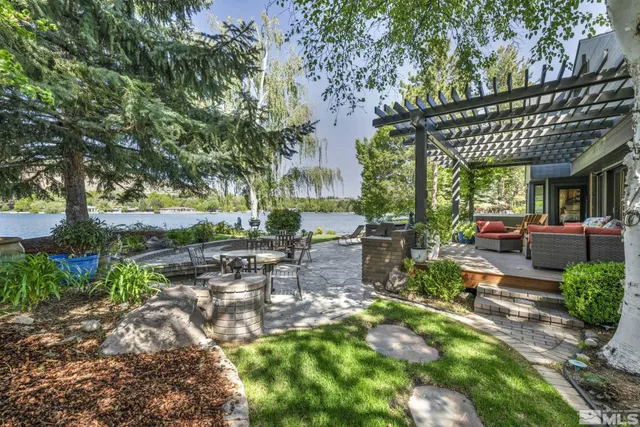 a view of a patio with table and chairs potted plants and large tree
