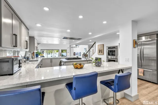 a kitchen with a sink and chairs