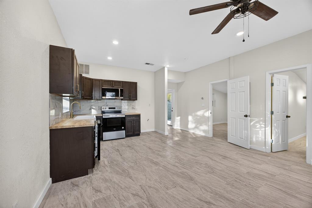 6775 Silver Creek Azle Road Azle, TX 76020 - Photo 25 of 40 Kitchen featuring dark brown cabinets, light countertops, appliances with stainless steel finishes, decorative backsplash, and a ceiling fan