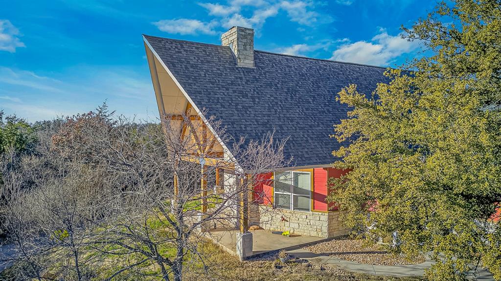 6775 Silver Creek Azle Road Azle, TX 76020 - Photo 33 of 40 View of property exterior with stone siding, roof with shingles, a chimney, and a patio area
