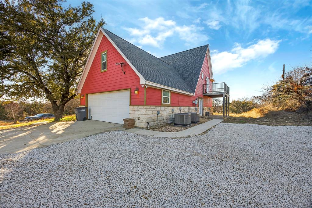 6775 Silver Creek Azle Road Azle, TX 76020 - Photo 5 of 40 View of side of home with concrete driveway, a shingled roof, stone siding, a garage, and a patio
