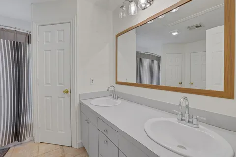 a bathroom with a double vanity sink and a mirror