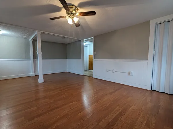 a view of empty room with wooden floor