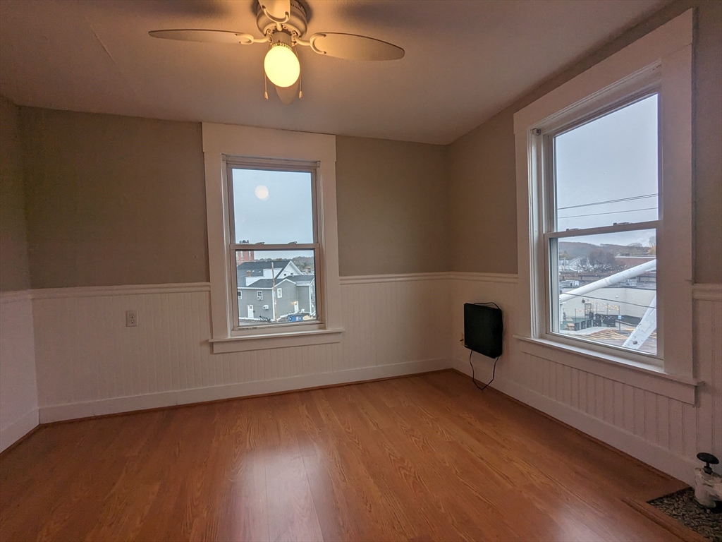 7 Congress Street, Unit 4 Milford, MA 01757 - Photo 10 of 11 an empty room with wooden floor fan and windows