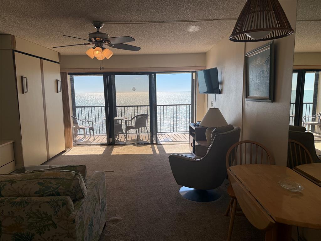 14950 Gulf Boulevard, Unit 805 Madeira Beach, FL 33708 - Photo 17 of 35 a living room with furniture and a chandelier