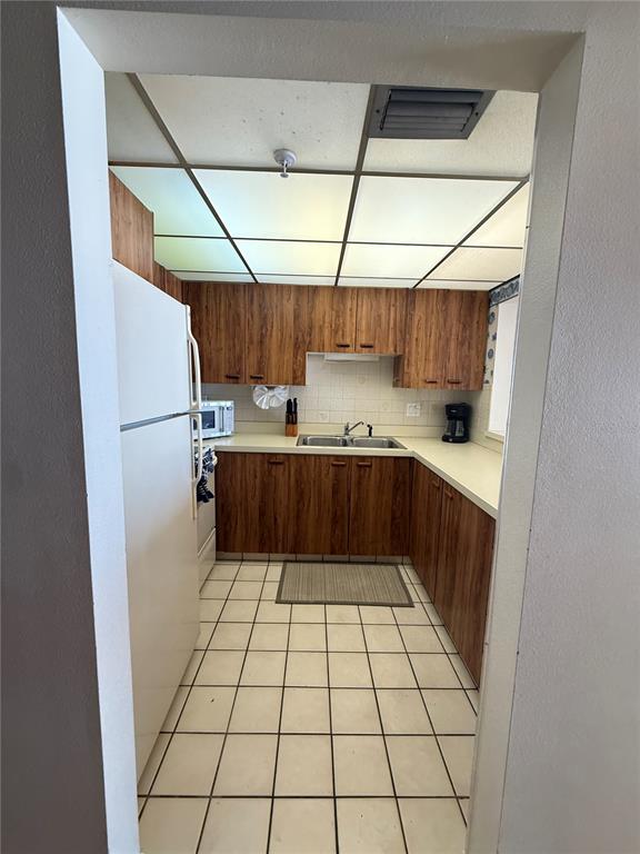 14950 Gulf Boulevard, Unit 805 Madeira Beach, FL 33708 - Photo 26 of 35 a kitchen with a refrigerator and a sink