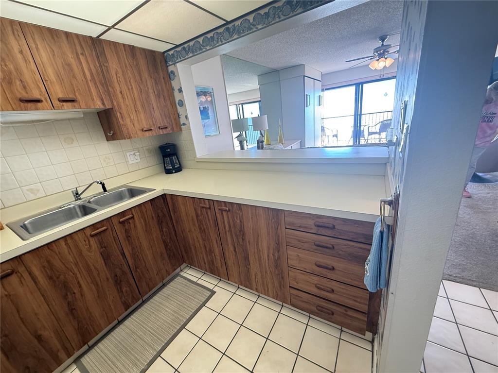 14950 Gulf Boulevard, Unit 805 Madeira Beach, FL 33708 - Photo 27 of 35 a kitchen with granite countertop wooden cabinets a sink and a stove