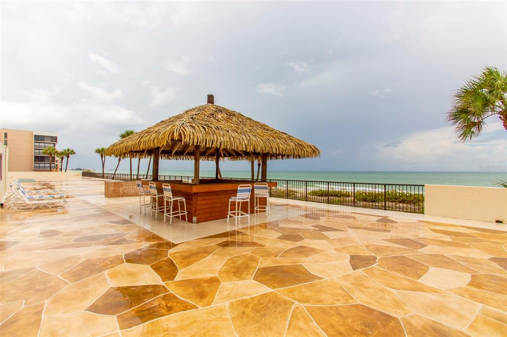14950 Gulf Boulevard, Unit 805 Madeira Beach, FL 33708 - Photo 7 of 35 a swimming pool with a table and chairs under an umbrella