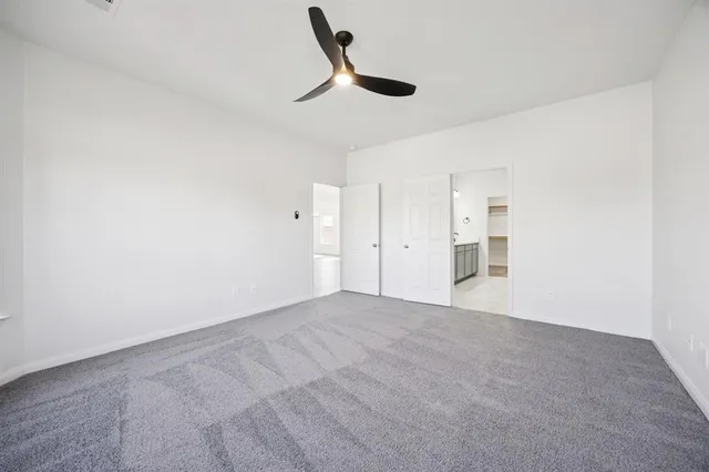 a view of empty room with ceiling fan