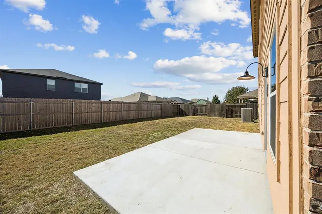 a view of backyard with wooden fence
