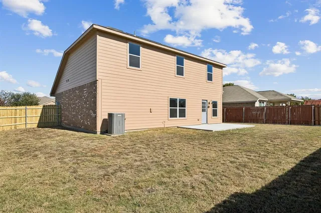 a view of a house with backyard and wooden fence