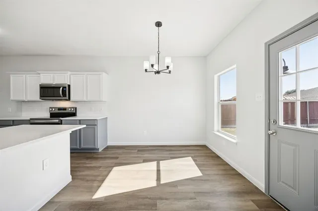 a kitchen with granite countertop a stove a sink and a refrigerator