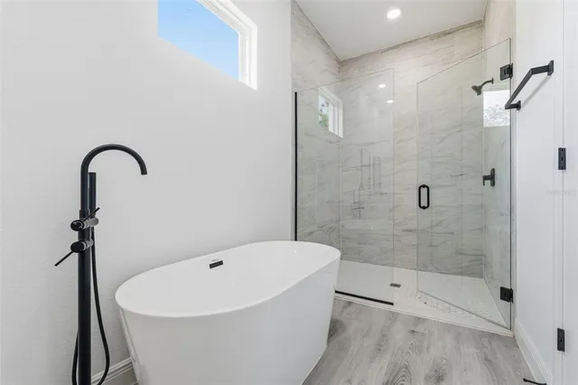 a white bath tub sitting next to a shower