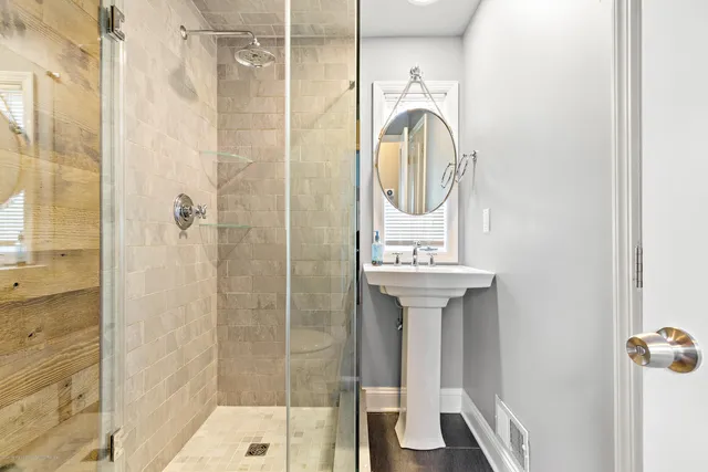 a bathroom with a shower a mirror and a sink