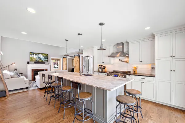 a kitchen with stainless steel appliances a table and chairs in it